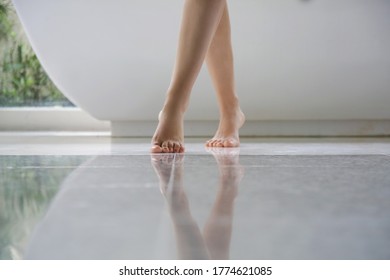 Barefoot womans legs in bathroom
