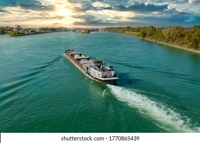 Barge travels on the Rhine in the sunset