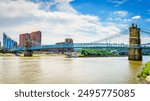 Barges are going under the Roebling Bridge in Cincinnati, Ohio