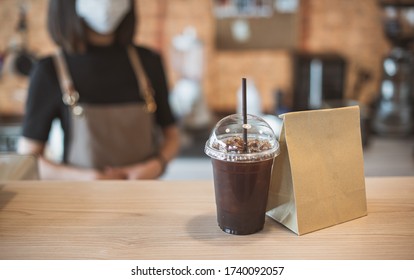 Barista  in apron and face mask standing  behind counter bar ready to give Coffee Service at the modern coffee shop, Modern cafe business, Social distancing concept.  - Powered by Shutterstock