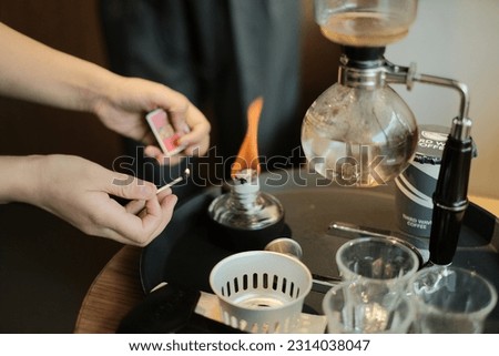 Barista brewing coffee using siphon,  Coffee brewing syphon method for coffee with hot water in coffee shop. vintage tone