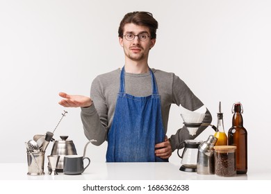 Barista, Cafe Worker And Bartender Concept. Portrait Of Confused And Judgemental Young Man In Apron, Shurgging Raise Hand In Dismay Look Skeptical, Complain Customer Bad Taste In Coffee