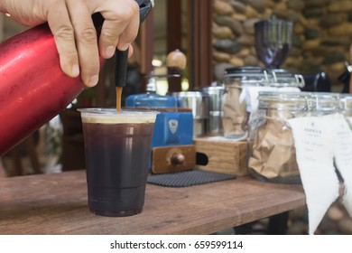 Barista Is  Forcing Nitrogen Into The The Coffee.Sparkling Nitro Cold Brew Coffee On Wood Table Outdoor Coffee Cafe