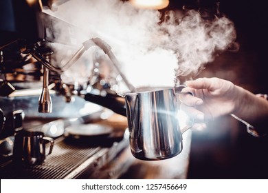 Barista heats milk with high-pressure steam for making lattes. - Powered by Shutterstock