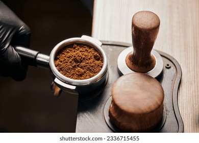 barista holding portafilter with grinded coffee, tamper, cafe, alternative brew, top view - Shutterstock ID 2336715455