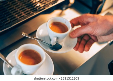 Barista holding two espresso cups on a countertop, showcasing freshly brewed coffee in a cozy café setting - Powered by Shutterstock