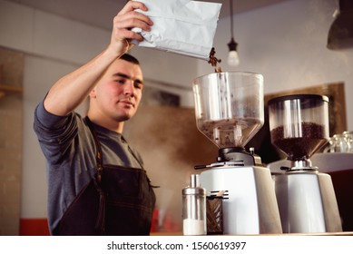 Barista makes espresso in cafe. Barista grind beans with coffee machine. Coffee grinder grinding roasted beans in powder. Fresh ground coffee in portafilter. - Powered by Shutterstock