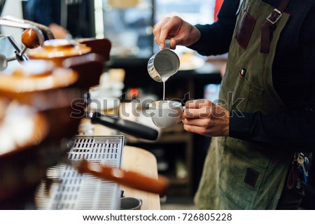 Barista making cappuccino, bartender preparing coffee drink 