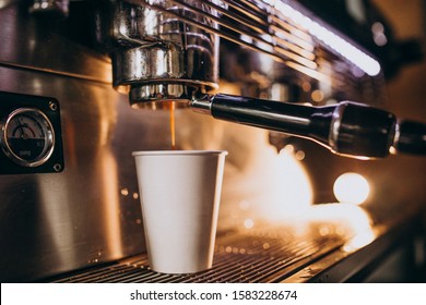 Barista making coffee in a coffee machine in a cardboard
