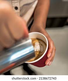 Barista making milk froth flat white coffee latte art takeaway cup coffeeshop professional rosette 
