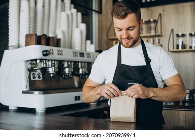 Barista packing take away snacks at a coffee shop - Powered by Shutterstock