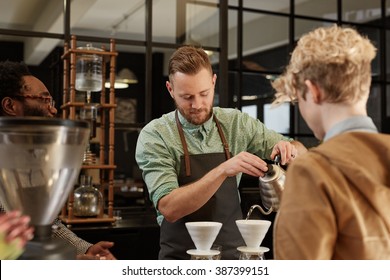 Barista pouring fresh coffee through filter in modern cafe - Powered by Shutterstock