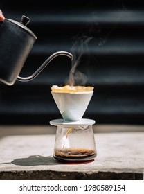 Barista is pouring hot water to make  filtered coffee, or pour over coffee in nature stone floor.vintage tone. hot water smoke - Shutterstock ID 1980589154