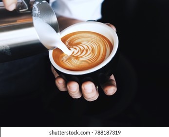 Barista pouring milk in coffee cup for make latte art. - Powered by Shutterstock