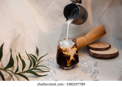 Barista Pouring Milk Into A Glass Of Iced Coffee