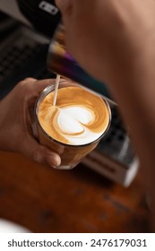 Un barista vierte leche