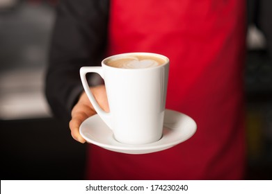 Barista prepares cappuccino in his coffee shop - Powered by Shutterstock