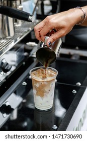 Barista Preparing Iced Coffee. Pouring Coffee Into The Glass With Milk And Ice.