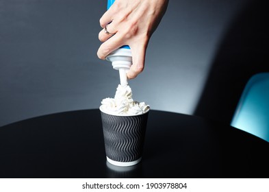 Barista Putting Whipped Cream On Coffee With Milk. Process Of Making Tasty Coffee Drink With Milk