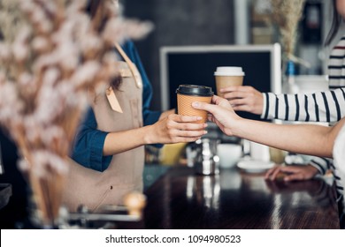 Barista served take away hot coffee cup to customer at counter bar in cafe restaurant,coffee shop business owner concept,Service mind waitress