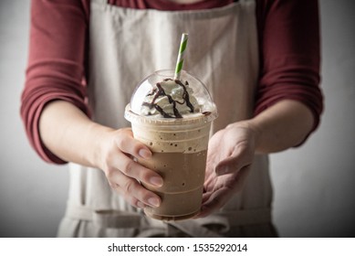 barista serving coffee frappe in plastic cup