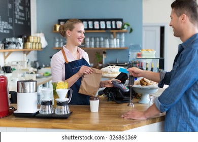 Barista Serving Customer In Coffee Shop
