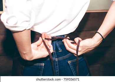 Barista tying up her apron around the waist - Powered by Shutterstock