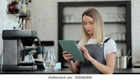 Barista using digital tablet in cafe. The female staff are checking the products in the store using tablets. Coffee shop concept. - Powered by Shutterstock