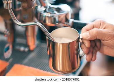 Barista is using high pressure steam operated milk frother to prepare a coffee milk. - Powered by Shutterstock