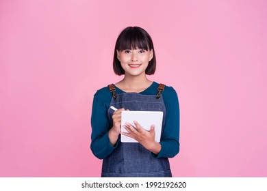 Barista waitress using smart tablet tech taking orders customer service café shop Asian woman start up small business owner employee worker entrepreneur occupation apron pink isolated background