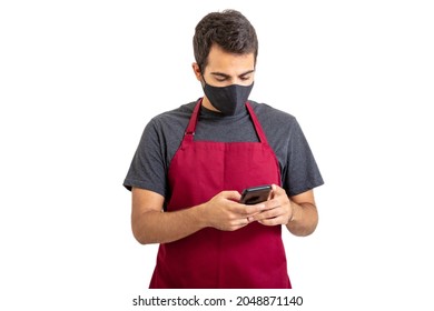 Barista wearing red apron and face protective mask using a mobile phone isolated against white background. Coffee and food business new normal coronavirus days concept - Powered by Shutterstock