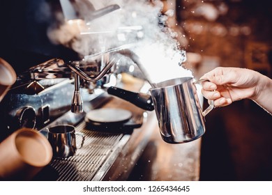 Barista Whips Milk With Nozzle, Strong Jet Of Air Steam Coffee Machine, Holding Pitcher In His Hand.