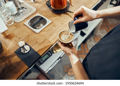 Barista woman making cappuccino, female preparing coffee drink. Coffee cup with latte art - Powered by Shutterstock