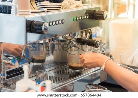 barista woman making coffee by espresso machine at café