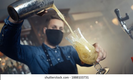 Barkeeper Wearing Apron Spilling Cocktail In Glass In Smoky Bar