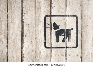 Barking Dog Silhouette In Black Color. Barking Dog Sign On A White Wooden Background. Guard Dog Inside Icon. Dog Barking Icon. Button Image On Wooden Background. Copy Space. Part Of A Series