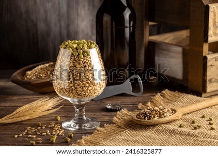 Barley and hops granulated in beer glass. Ingredients for craft beer.