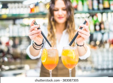 Barmaid preparing cocktails in a bar for her clients - Bartender at work in a club - Powered by Shutterstock