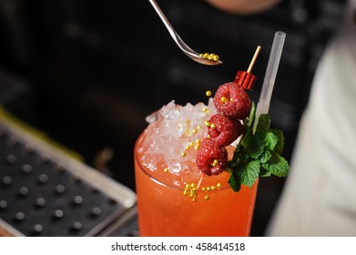 Barman Is Decorating Cocktail With Rasberry