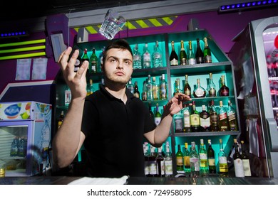 The barman is doing his work behind the counter