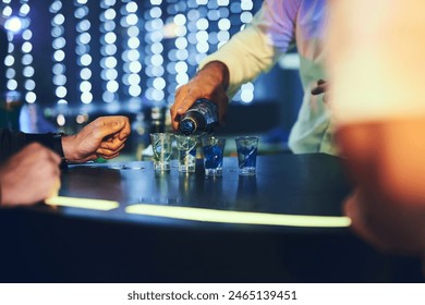 Barman, drinks and pour alcohol in night club for service, order and counter server with hospitality. Bartender, employee and prepare spirits in shot glasses at social event, happy hour and liquor - Powered by Shutterstock