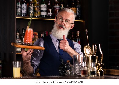 Barman Gray-haired Man With A Beard At Work, Preparing Cocktails, Senor Bartender With Serving Bloody Mary Cocktail, Concept About Service And Beverages.