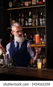 Barman Gray-haired Man With A Beard At Work, Preparing Cocktails, Senor Bartender With Serving Bloody Mary Cocktail, Concept About Service And Beverages.