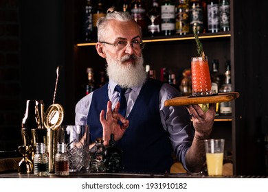 Barman Gray-haired Man With A Beard At Work, Preparing Cocktails, Senor Bartender With Serving Bloody Mary Cocktail, Concept About Service And Beverages.