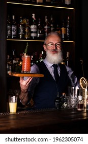 Barman Gray-haired Man With A Beard At Work, Preparing Cocktails, Senor Bartender With Serving Bloody Mary Cocktail, Concept About Service And Beverages.