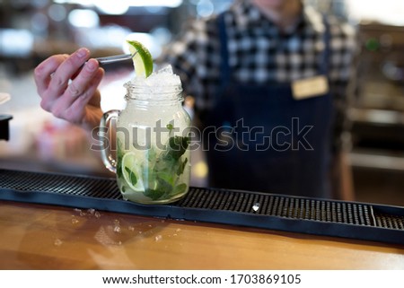 Barman makes a cocktail on the bar in the restaurant.