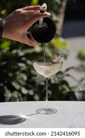 Barman Is Making Cocktail, Close-up. Bartender Making Alcoholic Cocktail At Table, Outdoor