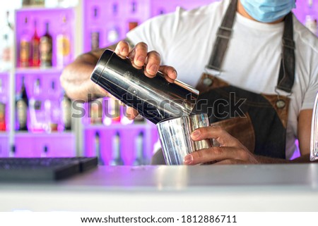 Barman making a cocktail with at night club.