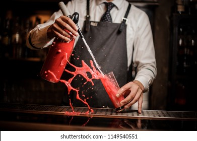 Barman Pouring Alcoholic Sparkling Water Into A Sweet Red Berry Summer Cocktail And Splashing Around On The Bar Counter