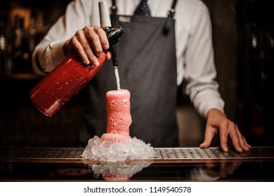 Barman Pouring Alcoholic Sparkling Water Into A Glass With Sweet Red Berry Summer Cocktail With Foam On The Bar Counter